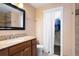 Bathroom with a wood vanity, decorative mirror and shower at 1780 Roslyn St, Denver, CO 80220