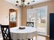 Sunlit dining area with sliding glass doors to the backyard, hardwood floors, and modern lighting at 1780 Roslyn St, Denver, CO 80220