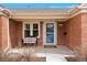 Inviting front porch with seating area, featuring a brick facade and bright entry door at 1780 Roslyn St, Denver, CO 80220