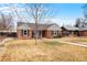 Lovely brick home with a blue door, complemented by a green lawn and traditional design at 1780 Roslyn St, Denver, CO 80220