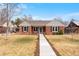 Charming brick home featuring a well-manicured lawn and inviting walkway to the front door at 1780 Roslyn St, Denver, CO 80220