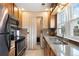 Well-lit kitchen features stainless appliances, mosaic backsplash, and a window overlooking the yard at 1780 Roslyn St, Denver, CO 80220