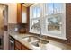 Close up on kitchen sink with granite countertops and a view to the backyard at 1780 Roslyn St, Denver, CO 80220