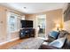 Bright living room with hardwood floors, a TV, and a view of the front yard from the window at 1780 Roslyn St, Denver, CO 80220