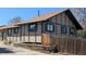 Tan and green trimmed home with a wooden fence and landscaped yard at 4710 E Louisiana Ave, Denver, CO 80246