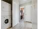 Functional hallway with laundry closet, leading to a bathroom with dark wood vanity at 4710 E Louisiana Ave, Denver, CO 80246