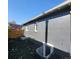 Exterior side view of a dark painted brick home with basement window access and mulch landscaping at 175 S Emerson St, Denver, CO 80209