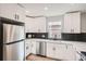 Bright kitchen features white cabinetry, stainless steel appliances and modern backsplash at 175 S Emerson St, Denver, CO 80209
