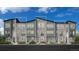 Modern townhome with stone accents, large windows, and a well-maintained lawn at 20618 E 63Rd Ave, Aurora, CO 80019