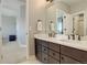 Bright bathroom featuring a double vanity with white countertop and dark wood cabinets at 23230 E Rockinghorse Pkwy, Aurora, CO 80016