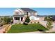 Inviting two-story home featuring manicured lawn, charming porch and a neutral color palette at 23230 E Rockinghorse Pkwy, Aurora, CO 80016