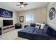 Cozy living room featuring a comfortable sectional sofa, tv set, and natural light from the window at 23230 E Rockinghorse Pkwy, Aurora, CO 80016