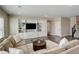 Comfortable living room with custom built-ins, a large TV, and a cozy sectional sofa at 23230 E Rockinghorse Pkwy, Aurora, CO 80016