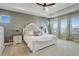 Bright main bedroom with a decorative ceiling, fan, dresser, and light from the two large windows at 23230 E Rockinghorse Pkwy, Aurora, CO 80016