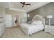 Spacious main bedroom with an ornate headboard, carpet and a hallway to an en-suite bathroom at 23230 E Rockinghorse Pkwy, Aurora, CO 80016
