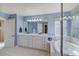 Spacious bathroom featuring double sinks, a large mirror, a soaking tub, and a window for natural light at 8641 Coors St, Arvada, CO 80005