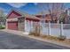 Exterior view of the house with an attached garage and white fence at 8641 Coors St, Arvada, CO 80005