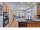 Modern kitchen featuring stainless steel appliances, granite countertops, and seamless flow into the living room at 8641 Coors St, Arvada, CO 80005