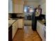 A well-maintained kitchen featuring clean white cabinets and a view into the dining area at 6649 Van Gordon Ct, Arvada, CO 80004