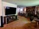 Spacious living room featuring a cozy brick fireplace, plush carpet, and a large entertainment center at 6649 Van Gordon Ct, Arvada, CO 80004