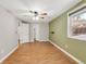 Spacious bedroom featuring a ceiling fan, wood floors, and a large window for ample natural light at 457 Verdant Cir, Longmont, CO 80504