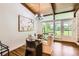 Elegant dining room with hardwood floors, a glass-top table, and backyard view at 845 Everett St, Lakewood, CO 80215