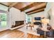 Bright living room featuring a brick fireplace, wood ceiling beams, hardwood floors, and a comfortable seating area at 845 Everett St, Lakewood, CO 80215
