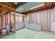 Unfinished basement with stud framing and grey cabinets with wooden countertops at 1570 S Chase St, Lakewood, CO 80232