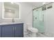 A renovated bathroom features a new vanity with an LED mirror and a frameless glass shower at 1570 S Chase St, Lakewood, CO 80232
