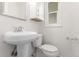 Updated bathroom with pedestal sink and window at 1570 S Chase St, Lakewood, CO 80232