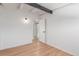 Bright bedroom with light hardwood floors, black accent beam, and closet at 1570 S Chase St, Lakewood, CO 80232