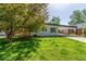 Charming home with lush front yard and covered parking offers great curb appeal at 1570 S Chase St, Lakewood, CO 80232