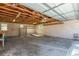 An unfinished garage with exposed ceiling beams offers room for parking and storage at 1570 S Chase St, Lakewood, CO 80232