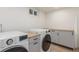 This laundry room showcases modern, front-load washer and dryer units, plus ample counter space at 1570 S Chase St, Lakewood, CO 80232
