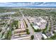 A high aerial view shows townhomes near a lake and shopping areas, surrounded by mature trees in a green residential area at 13043 W 20Th Ave, Golden, CO 80401