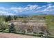 View of townhomes surrounded by mature trees, set against a mountainous landscape underneath a partly cloudy sky at 13043 W 20Th Ave, Golden, CO 80401