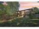 Exterior of a home, featuring a lush backyard, a wooden deck, and mature trees at 11112 Dahlia Way, Thornton, CO 80233