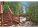 Outdoor deck, accessible by stairs, offering a secluded space surrounded by lush trees and greenery at 11112 Dahlia Way, Thornton, CO 80233