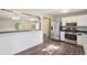 An open kitchen with stainless steel appliances, a pass-through to living area and modern flooring at 11112 Dahlia Way, Thornton, CO 80233