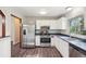 Bright kitchen with stainless steel appliances, white cabinetry, and dark countertops with modern flooring at 11112 Dahlia Way, Thornton, CO 80233