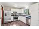 Spacious kitchen featuring stainless steel appliances, white cabinets, dark countertops, and modern flooring at 11112 Dahlia Way, Thornton, CO 80233