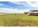 Spacious backyard with lush green grass and a charming shed plus covered porch; perfect for relaxation and outdoor activities at 46303 E 106Th Ave, Bennett, CO 80102