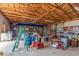 Spacious barn interior featuring exposed wooden beams, shelving, and concrete flooring at 46303 E 106Th Ave, Bennett, CO 80102