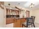 Basement wet bar with stone countertop, wood cabinetry, and decorative accents at 46303 E 106Th Ave, Bennett, CO 80102