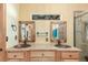 Modern bathroom featuring double copper sinks, granite countertop, and two wood-framed mirrors at 46303 E 106Th Ave, Bennett, CO 80102