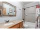 Well-lit bathroom with granite vanity, framed mirror, and tiled shower-tub combination at 46303 E 106Th Ave, Bennett, CO 80102