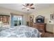 Main bedroom features wood floors, ceiling fan, backyard views, and a large dresser with TV at 46303 E 106Th Ave, Bennett, CO 80102