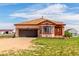 Tan home with brown garage door and red trim nestled on a sprawling green lawn with blue skies above at 46303 E 106Th Ave, Bennett, CO 80102