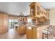 Spacious kitchen features custom wood cabinets, granite countertops, and a center island with cooktop at 46303 E 106Th Ave, Bennett, CO 80102