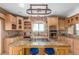 Gourmet kitchen island with granite countertop, gas cooktop, pot rack, and custom wood cabinetry at 46303 E 106Th Ave, Bennett, CO 80102